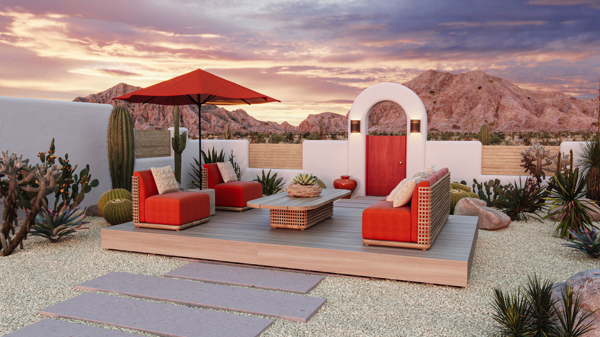 An outdoor patio is shown in this image with orange-cushioned furniture on top of it. There is a path to the deck with the seating area. The patio looks out towards mountains There are cacti and boulders beside the walls of the patio.